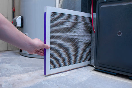 hand replacing furnace filter