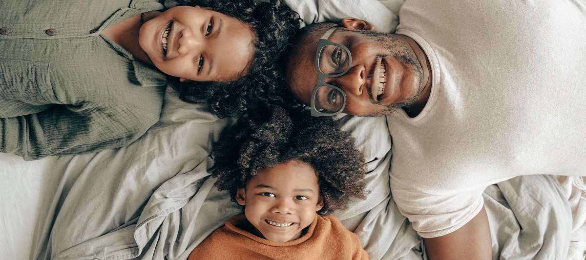 Happy family of three smiling up at the camera