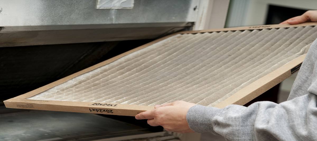 Person removing a dirty air filter