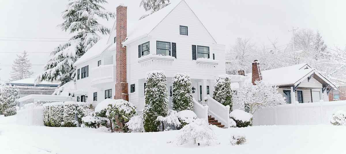 Two-story home covered in snow