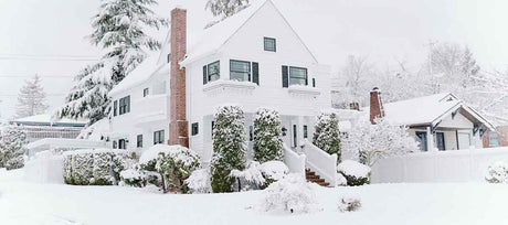 Two-story home covered in snow